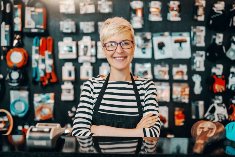 photo of small business owner standing in front of products, HR management software for small businesses