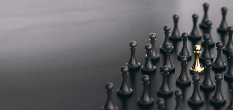 Black pawns surrounding a golden pawn to represent finding the perfect candidate in a sea of others in relation to talent management